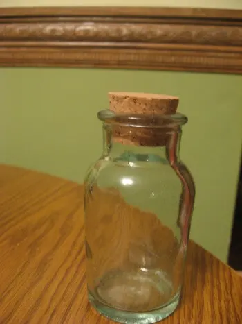 Vintage-style glass cork-topped spice bottle on table.