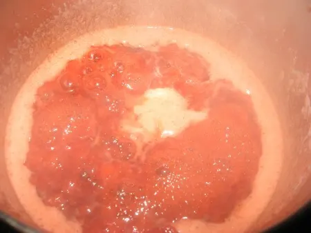 Strawberry sauce boiling in a pot.