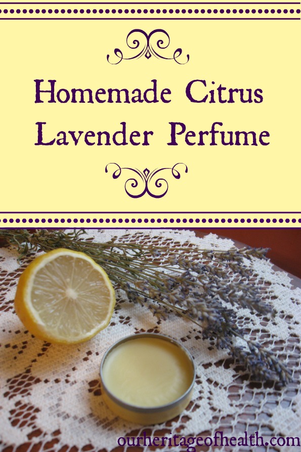 A tin of homemade solid perfume on a lace cloth with a cut lemon and sprigs of lavender beside it.
