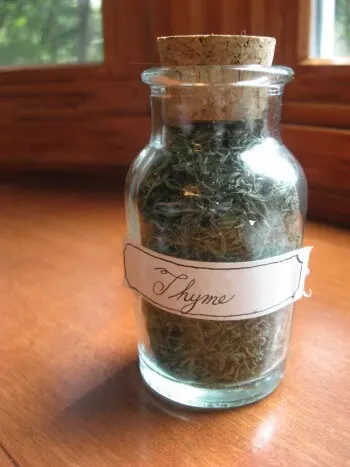 Cork-topped bottle of dried thyme leaves.