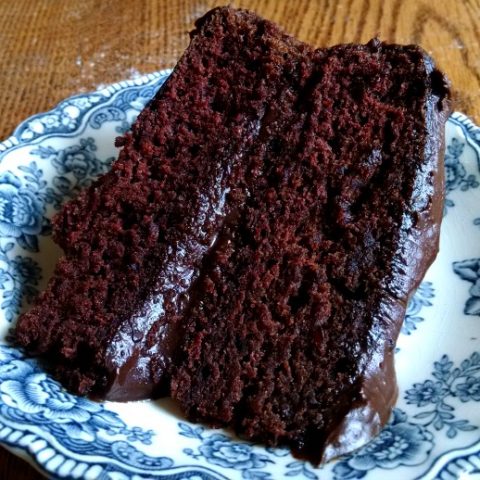 Slice of chocolate cake on blue plate.