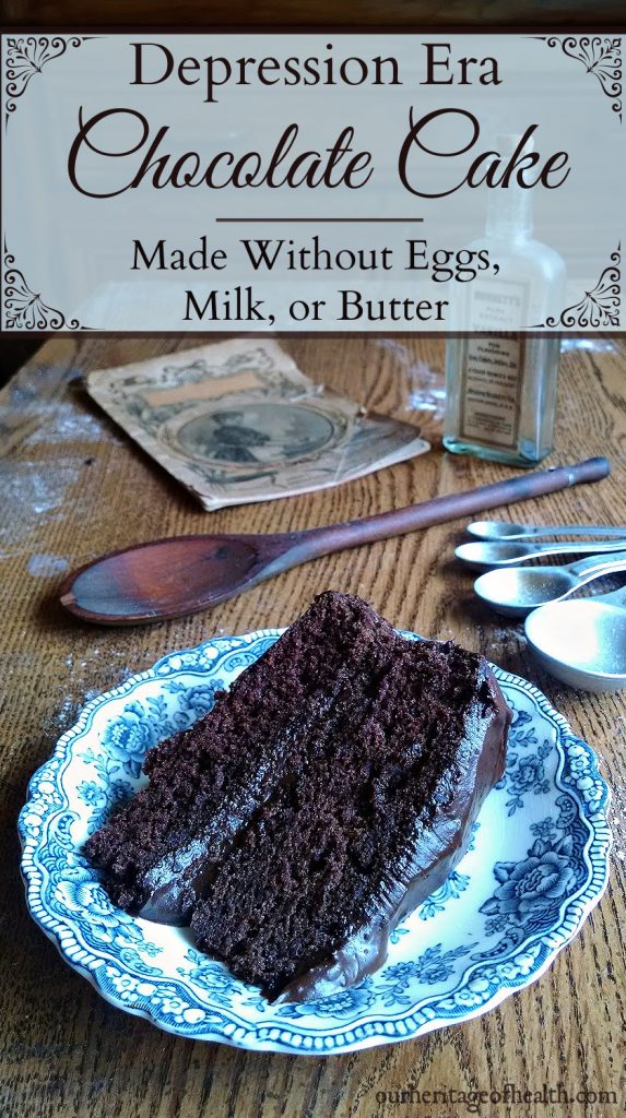 Slice of chocolate cake on a blue plate on a table with measuring spoons and a mixing spoon and cookbook in the background.