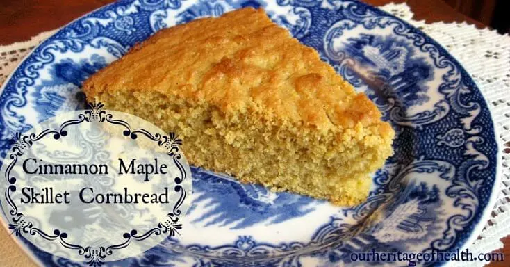 Triangular slice of skillet cornbread on a blue china plate.