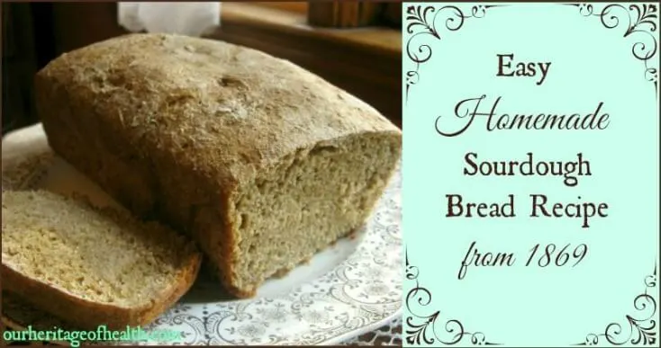 Loaf of sourdough bread on a plate with a slice cut out of it.