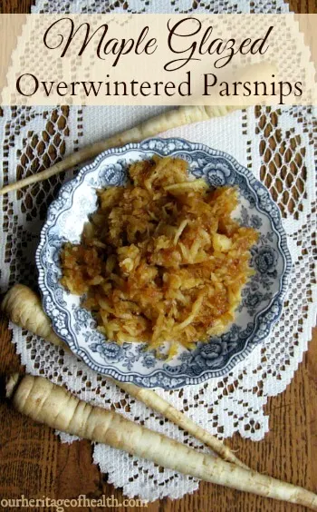Blue and white china dish with maple-glazed parsnips on a lace table runner with whole parsnips beside it.