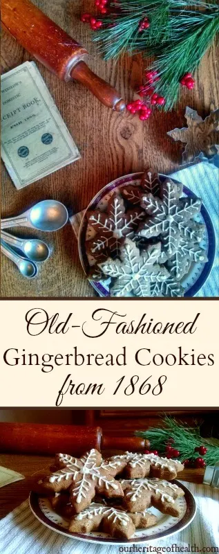 Plate of gingerbread cookies shaped like snowflakes with white icing on a table with a rolling pin, cookie cutter, measuring spoons, pine boughs, red berries, and an antique cookbook.