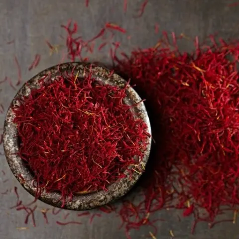 saffron threads in bowl and on table