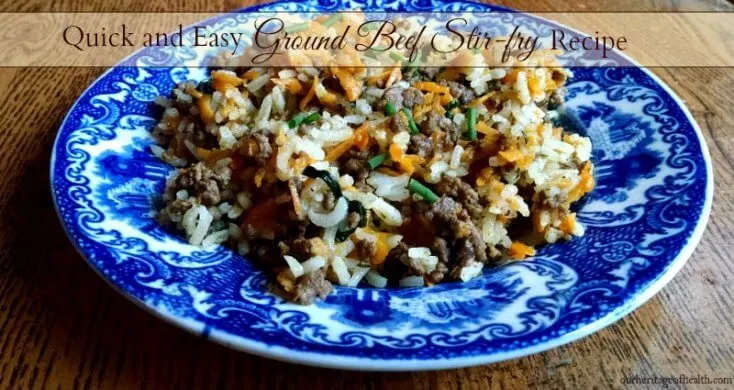 Ground beef stir fry on blue plate on table.