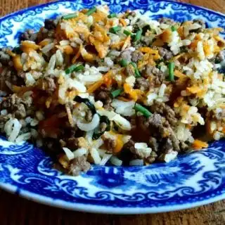 Ground beef stir fry on blue plate on table