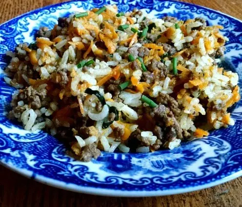 Ground beef stir fry on blue plate on table