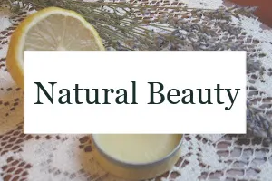 Homemade perfume with a sliced lemon and lavender sprigs with the text overlay "Natural Beauty."