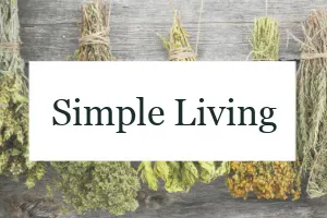 Bundles of herbs hanging to dry with the text overlay "Simple Living."