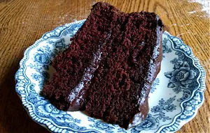 Slice of chocolate cake on a blue plate.