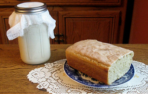 Loaf of bread next to a jar of sourdough starter.