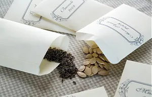 Seed packets on a table with seeds spilling out.