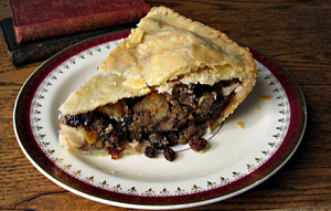 Slice of mincemeat pie on a white plate rimmed with crimson.