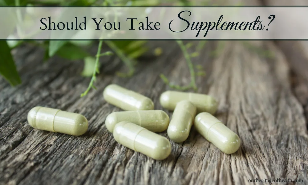 Supplement capsules on a wooden table with green leaves in the background.