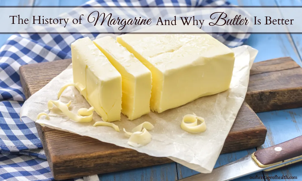 Butter sliced into pieces on a cutting board with a blue checked towel in the background.