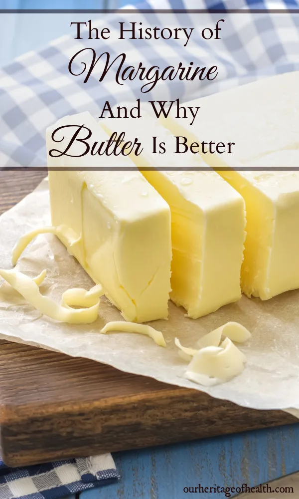 Butter sliced into pieces on a cutting board with a blue checked towel in the background.