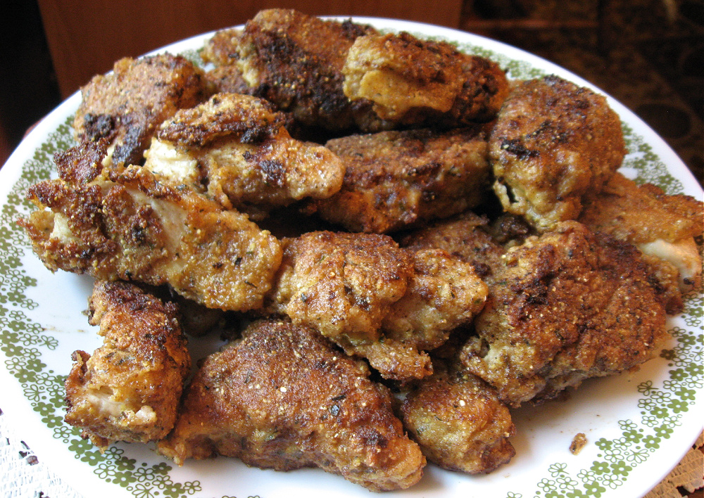 Fried chicken coated in homemade breading mixture on a plate.