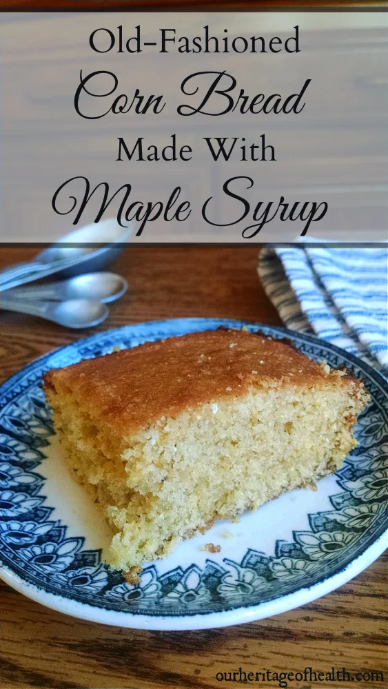 Square slice of corn bread on a blue and white china plate on a table with measuring spoons and a blue and white striped towel beside it.