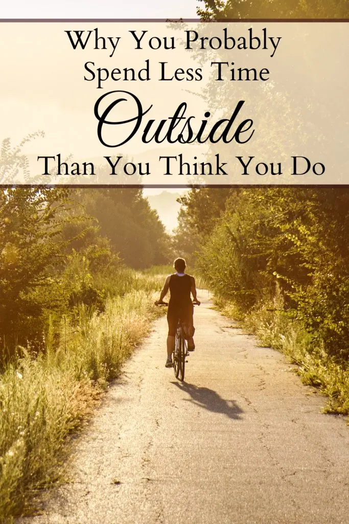 Woman riding on a bicycle through a nature path in the glow of the sunlight with a text overlay that says "Why You Probably Spend Less Time Outside Than You Think You Do."